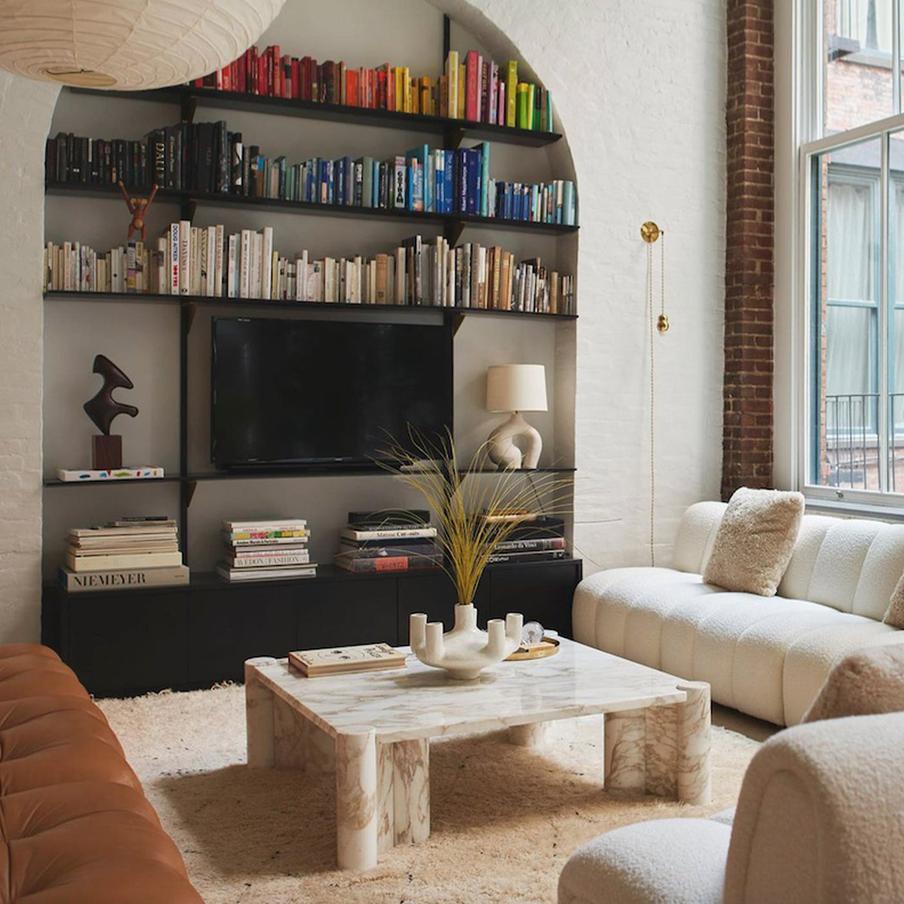 В зоне отдыха расположены полки с книгами, выставленными по цветам.