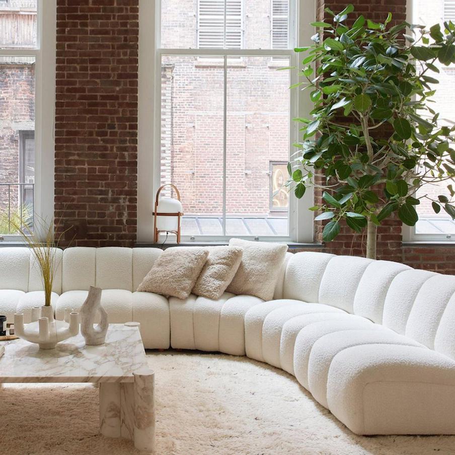 В пространстве стильно сочетается кирпичная стена, мягкие ковры и мрамор.