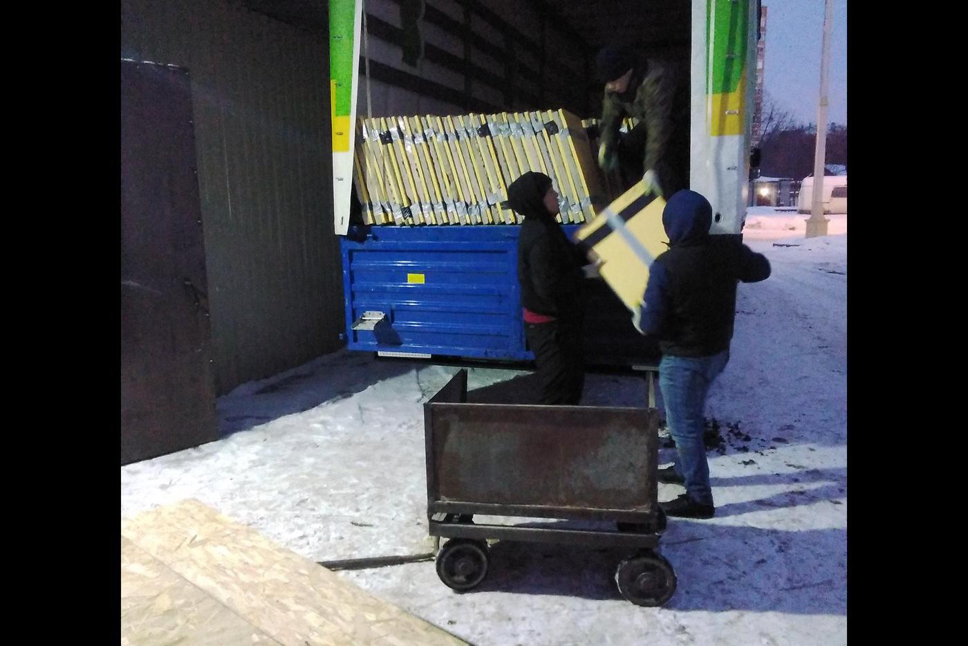 Разгружают машину с панно.