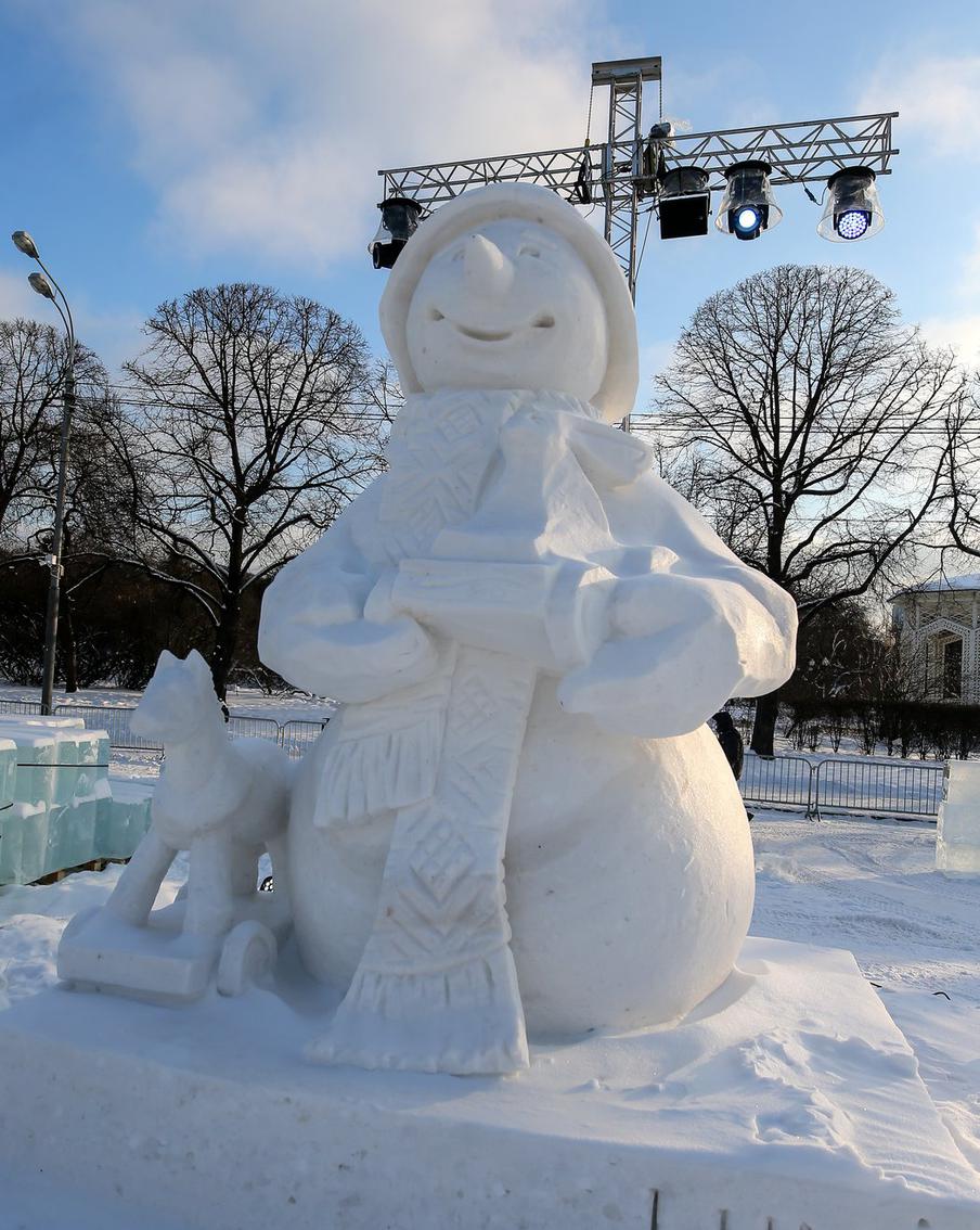 Скульптура снеговика с детской игрушкой