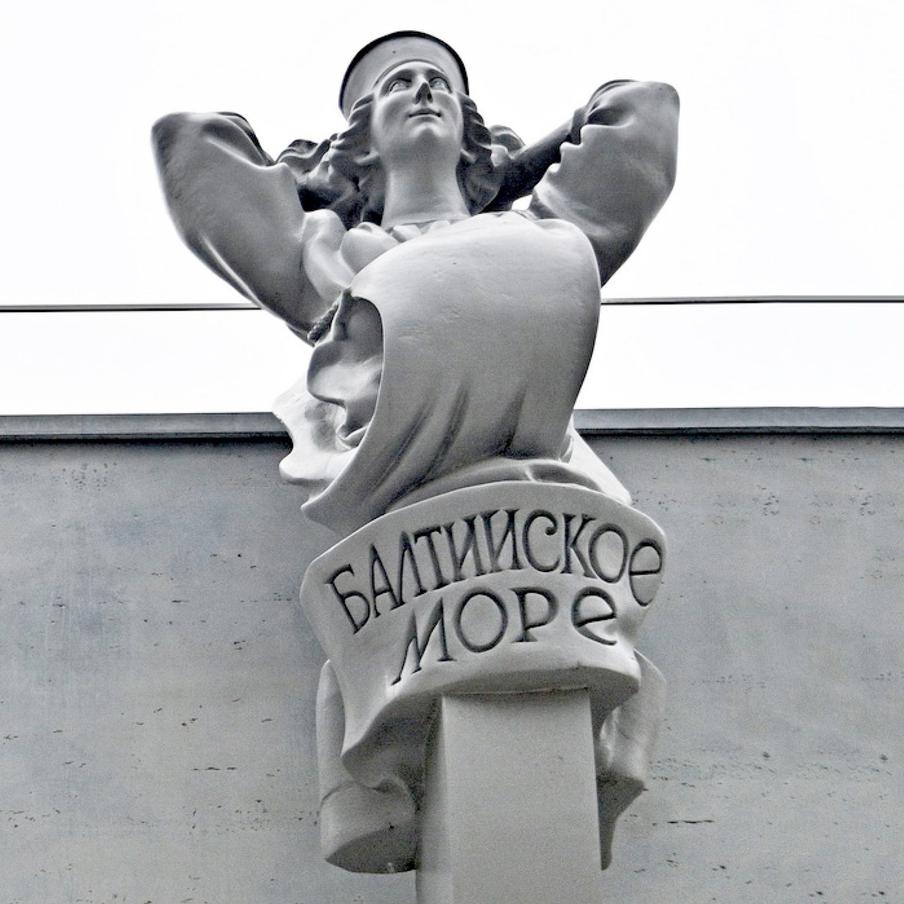 Побережье Балтийского моря населяли славянские, угрофинские и прибалтийские народы. Поэтому на голове женщины – северославянский кокошник, а широкое платье, покрывающее её тело, развевается на груди подобно парусу. Так как скульптуры задумывались в качестве ростр на носах кораблей, девушка закинула руки за голову, чтобы грудью, то есть «парусом», встречать попутный ветер в необъятном море.