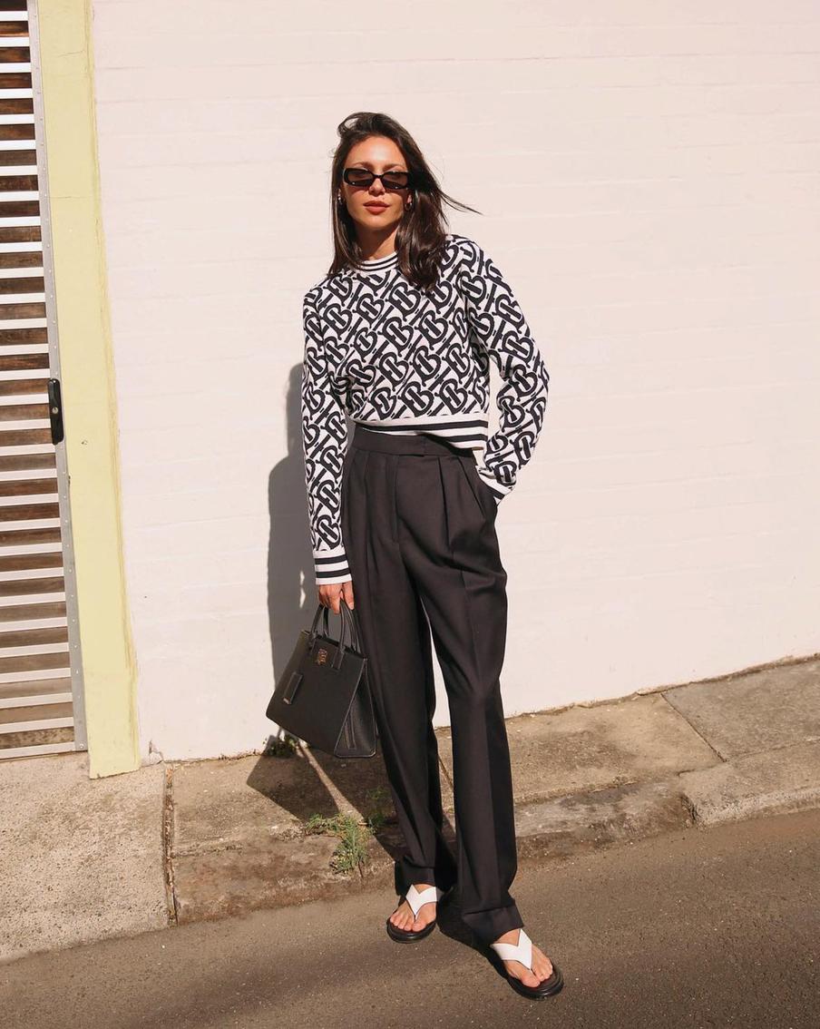 С классическими брюками и джемпером.