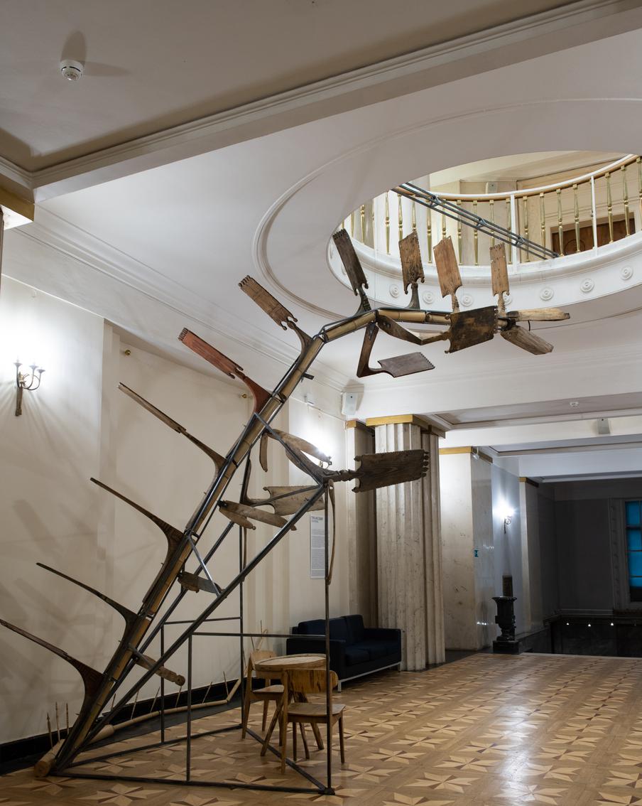 Высоченную инсталляцию держит сварочная конструкция, а стул со столом под ней – фотозона для посетителей