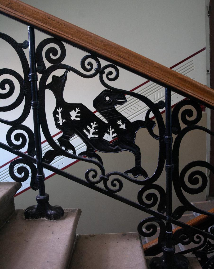 На лестничных пролётах с первого по пятый этажи – чугунные решётки начала XX века, на которых выкованы драконы.