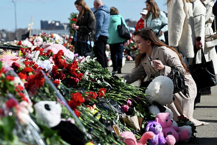 Люди собираются на панихиду у мемориала на месте трагедии в "Крокусе"