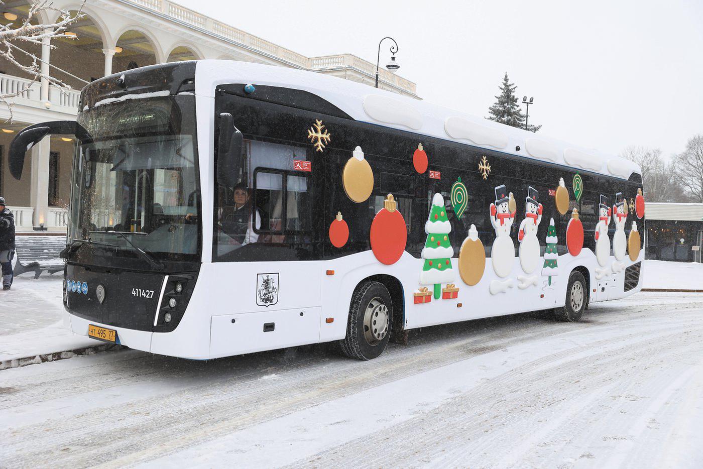 Украшенные белые автобусы смотрятся по-особому новогодне на фоне заснеженной Москвы.