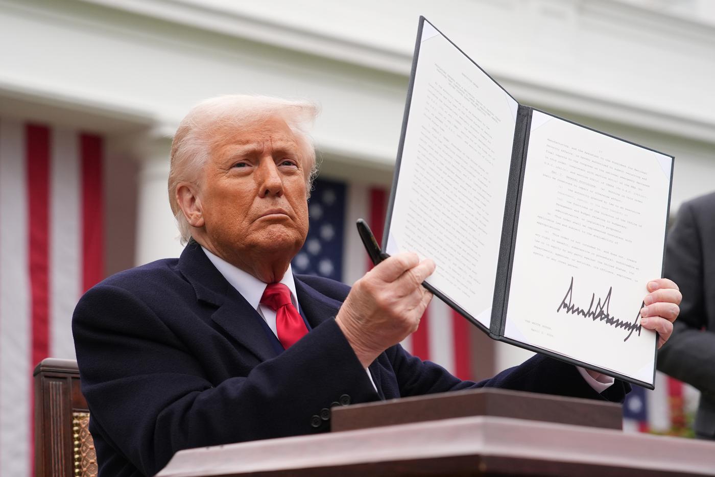 Дональд Трамп показывает подпись на апрельском указе о повышении тарифов.