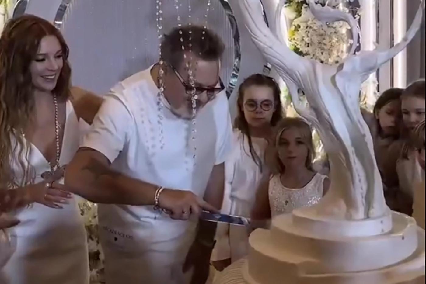 Владимир Пресняков режет свадебный торт-дерево.