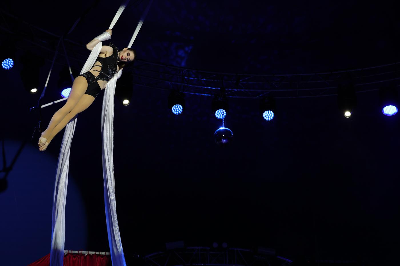 Гимнастка исполняла трюки на полотнах прямо под куполом шапито.