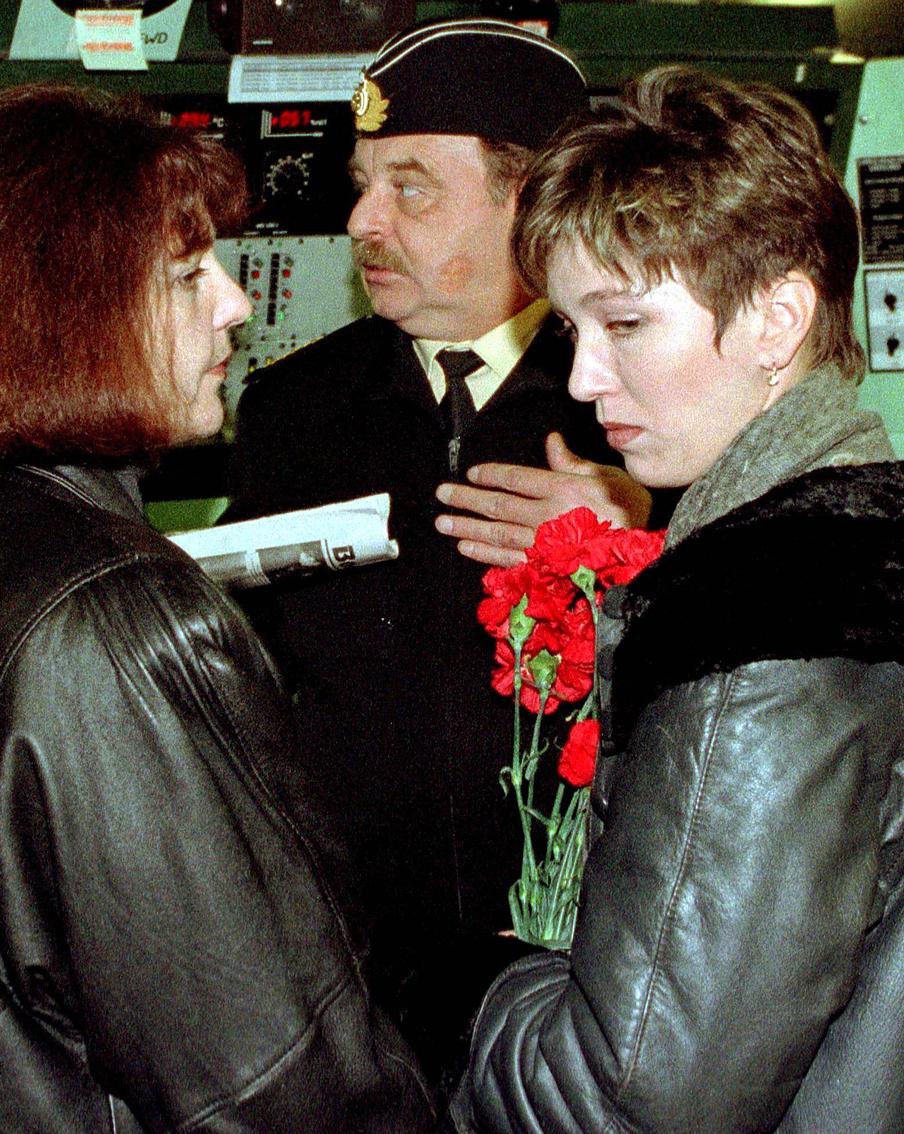 Оксана Силогава (справа) и Ирина Шубина, вдова подводника Александра Шубина, слушают доклад командующего Северным флотом России Вячеслава Попова.