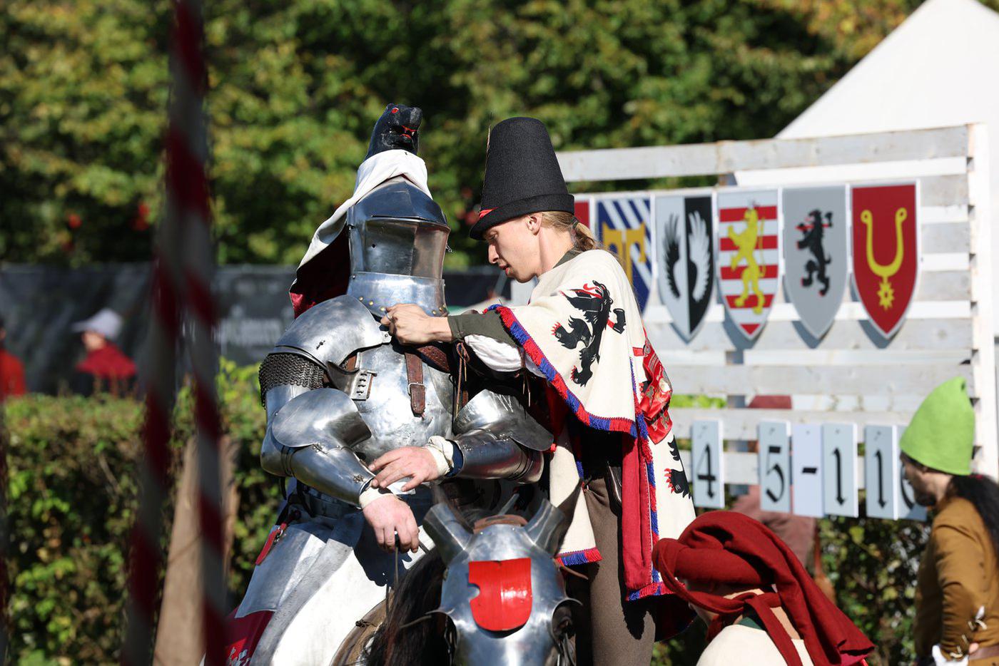 На ристалище рыцарь заезжает без шлема, а перед боем надеть его помогает оруженосец.