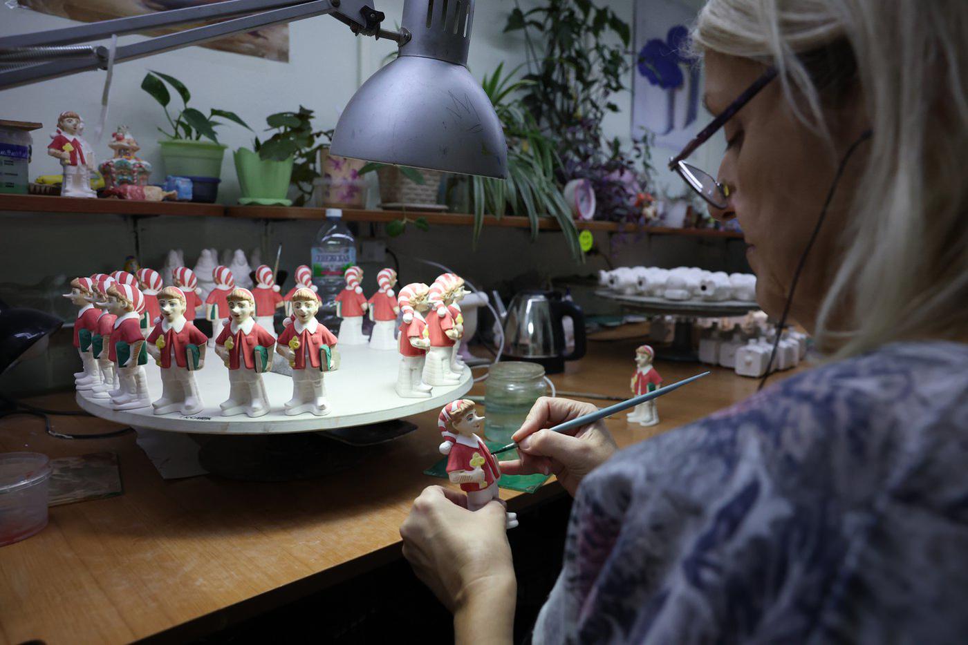 Окрашенные деревянные мальчики выстроились в настоящий хоровод на специальной подставке.