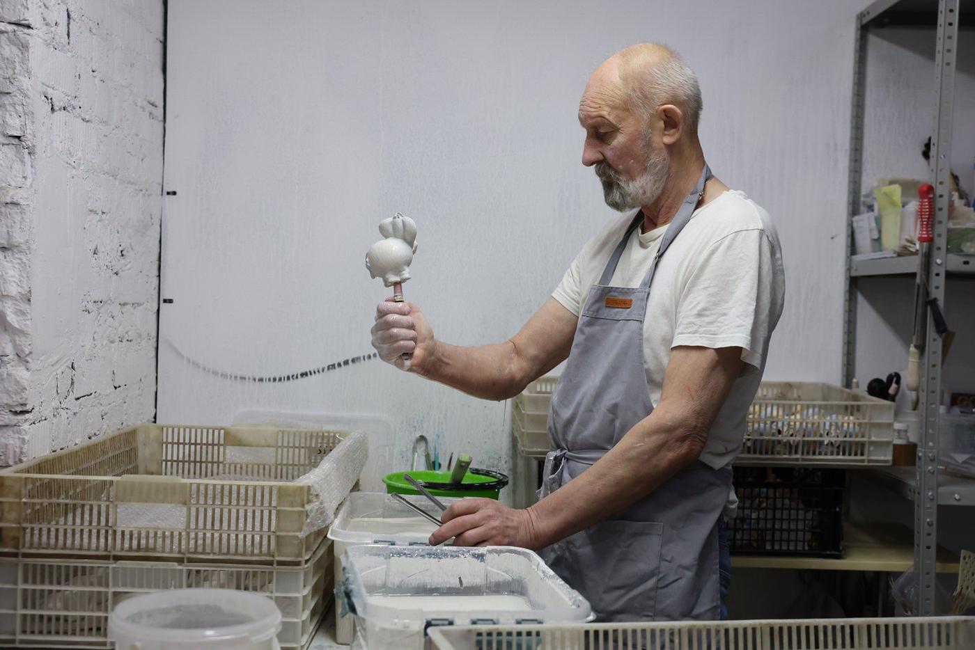 Мастер Константин покрывает уже расписанную ирушку глазурью – Ослик Иа стал белым, но при обжиге цвет вернётся.