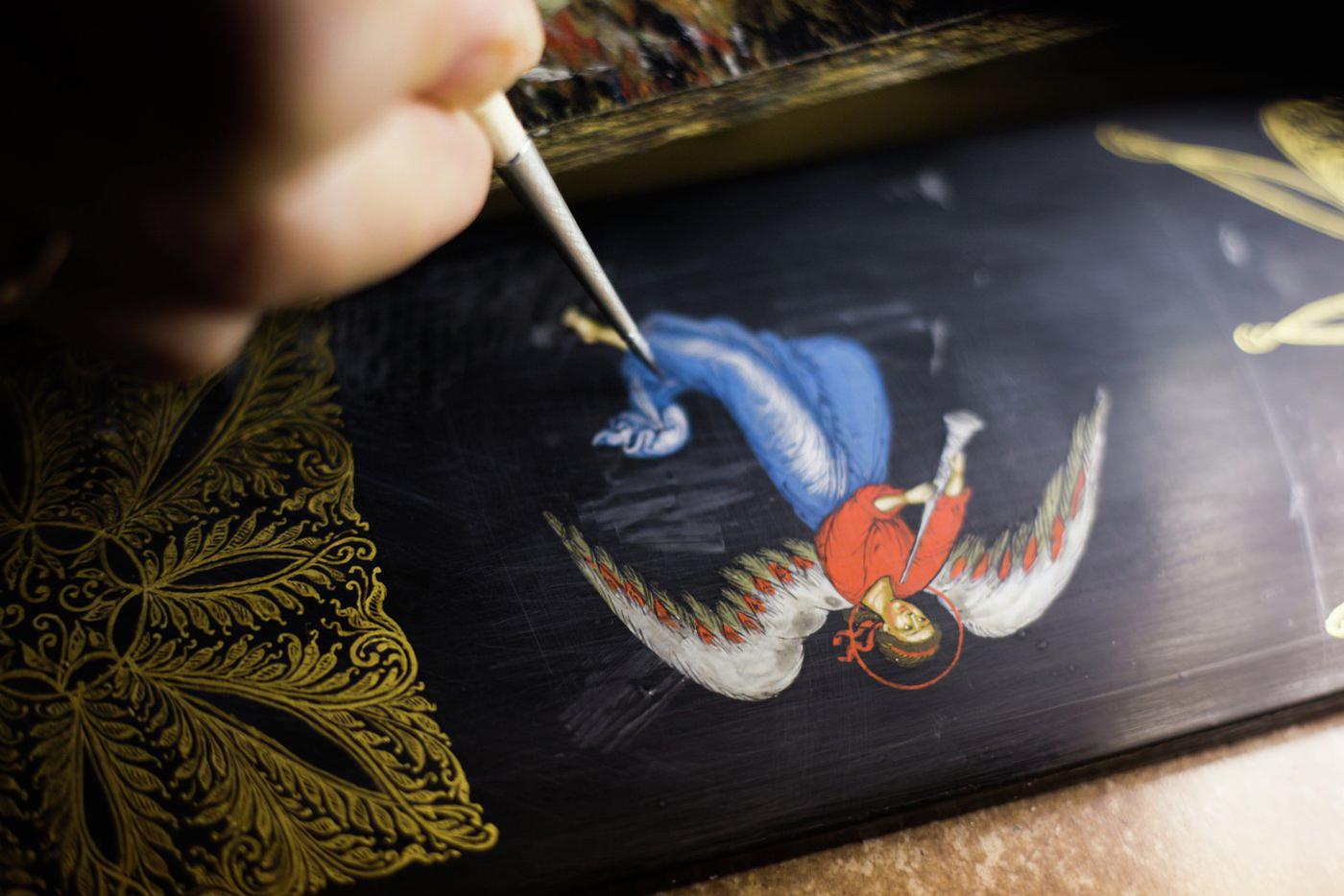 Художница лаковой миниатюры за работой.