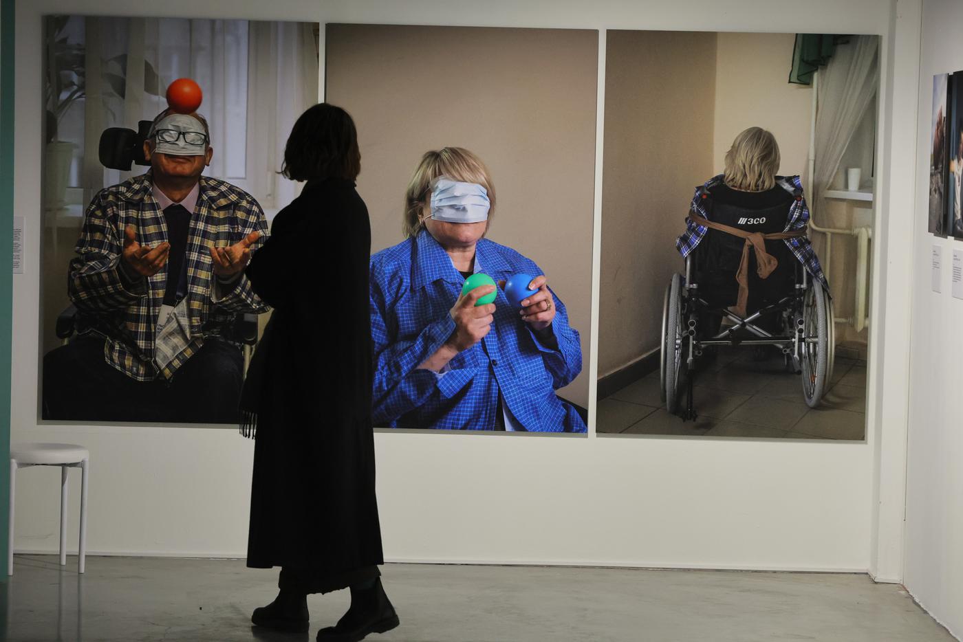 Один из посетителей выставки заворожённо рассматривает фотографии.