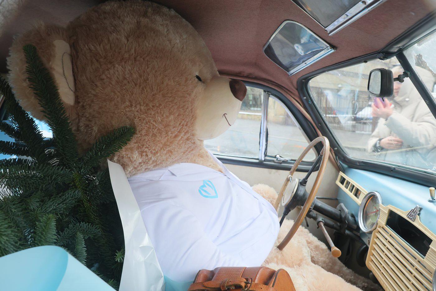 За рулём "Победы" сидит большой плюшевый медведь.