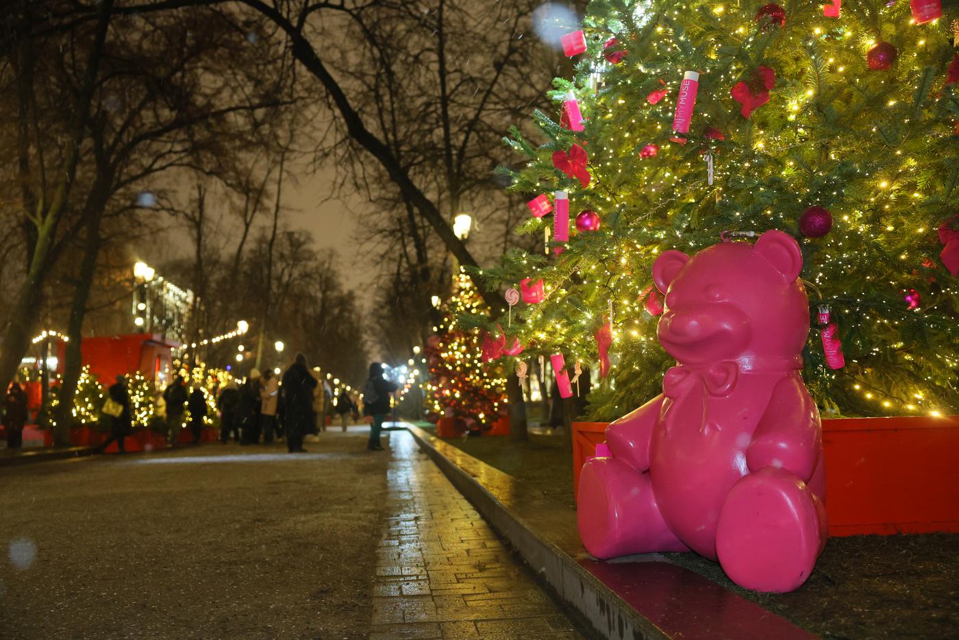 Розовый медведь нашёл ёлку себе в тон и уселся прямо под ней.