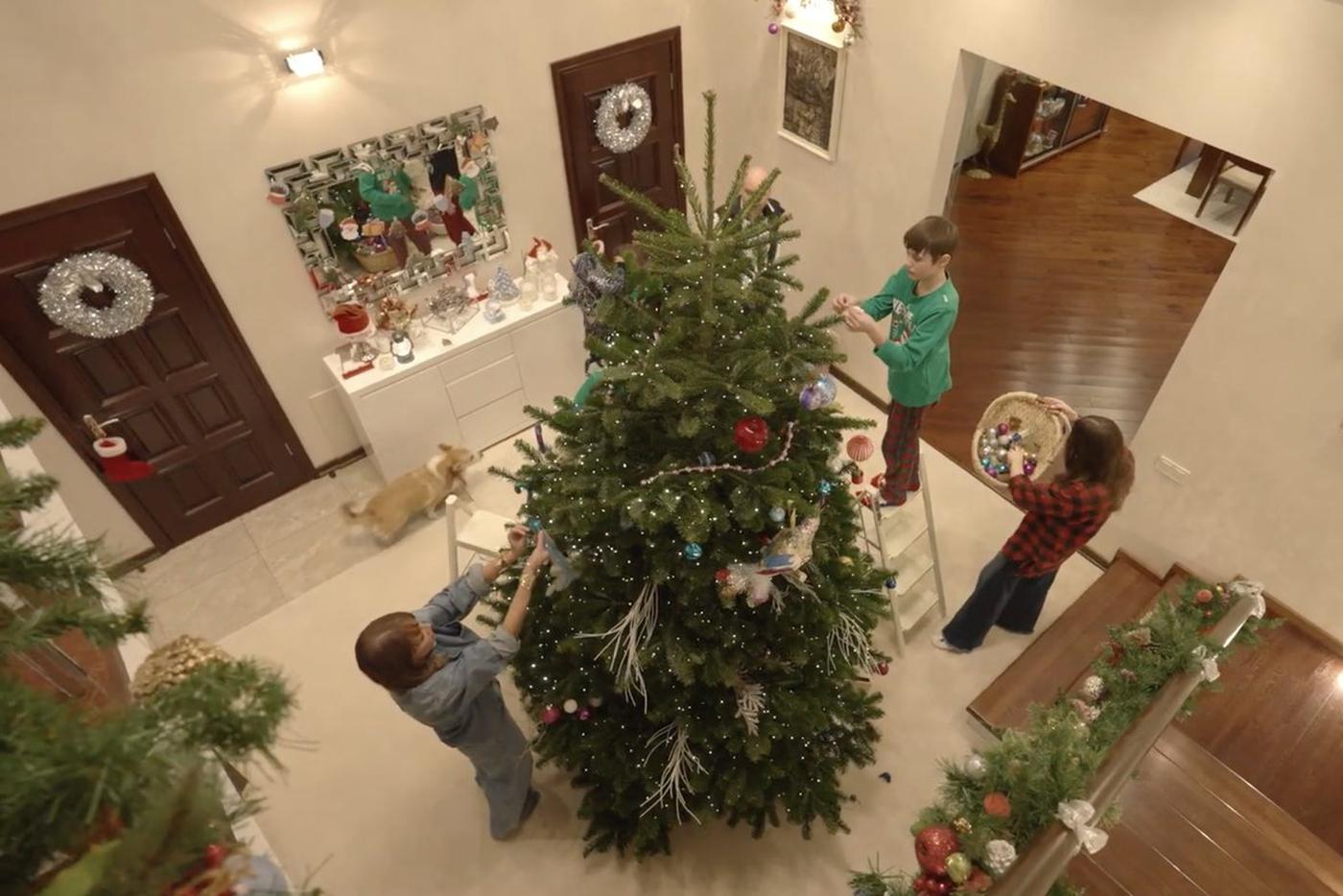 Семья в полном составе декорирует дом к празднику.