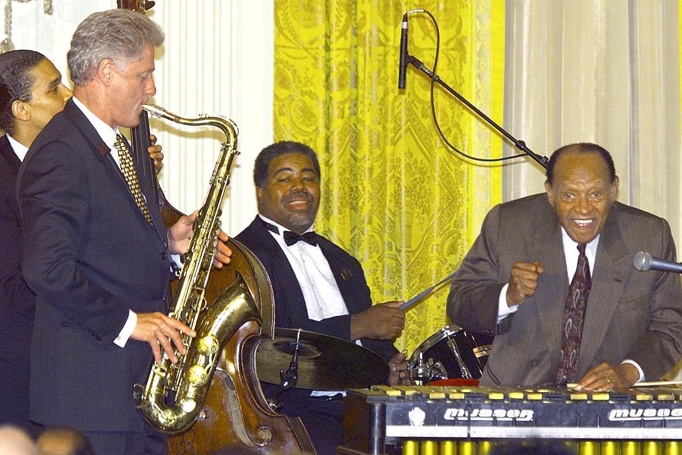 Президент США Билл Клинтон (слева) играет на саксофоне рядом с великим джазменом Лайонелом Хэмптоном (справа) во время празднования 90-летия Хэмптона в Восточном зале Белого дома в Вашингтоне.