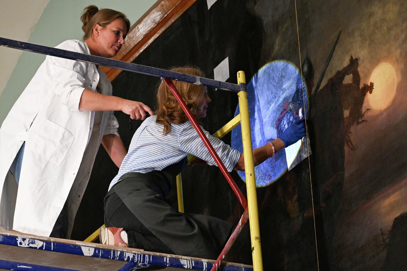 Художники-реставраторы Ирина Крылова (слева) и Ирина Владимирова во время реставрации полотна Генриха Семирадского "Тризна дружинников Святослава после боя под Доростолом" в зале Государственного исторического музея в Москве. 