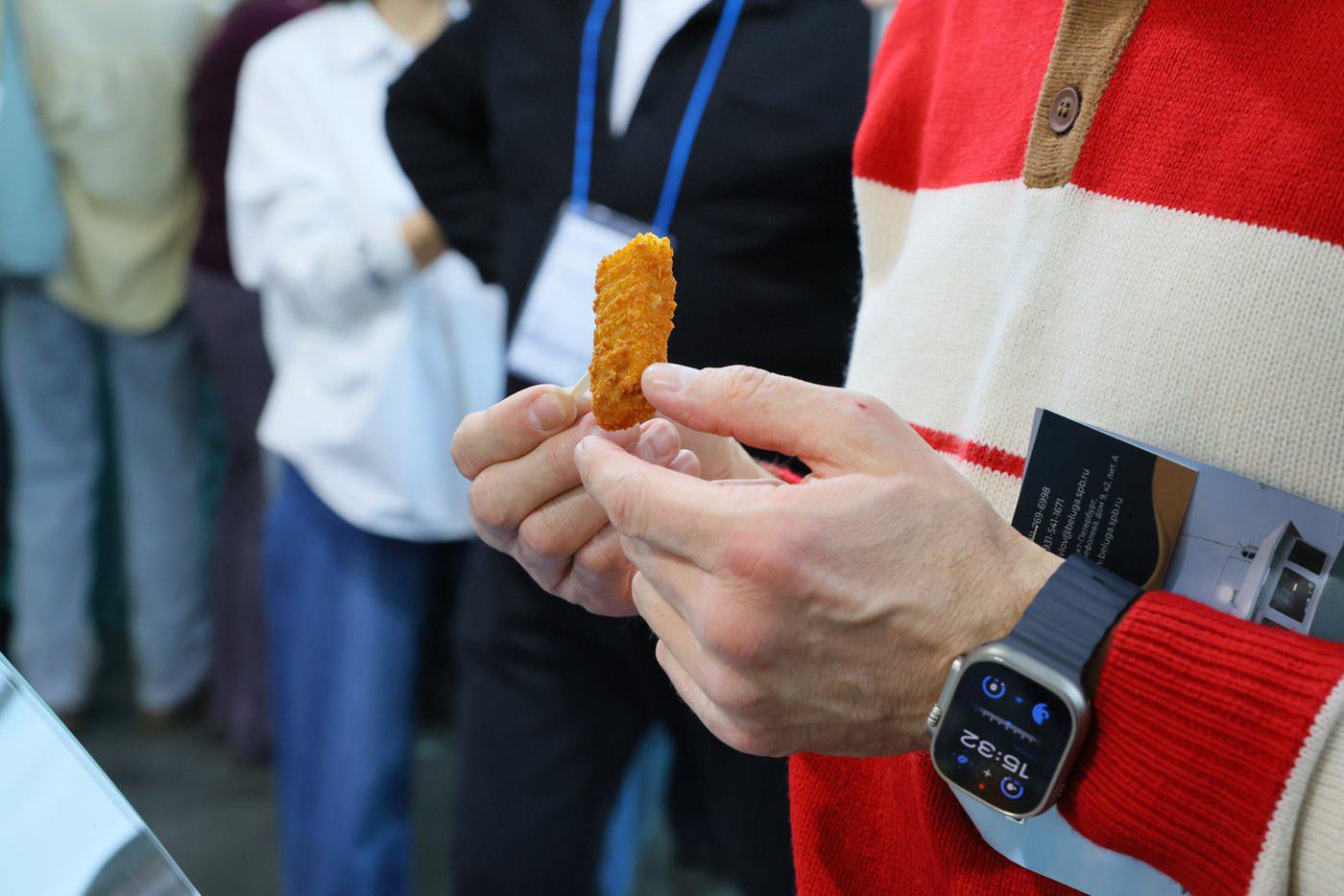 В руках у мужчины – наггетс из аргентинского хека.