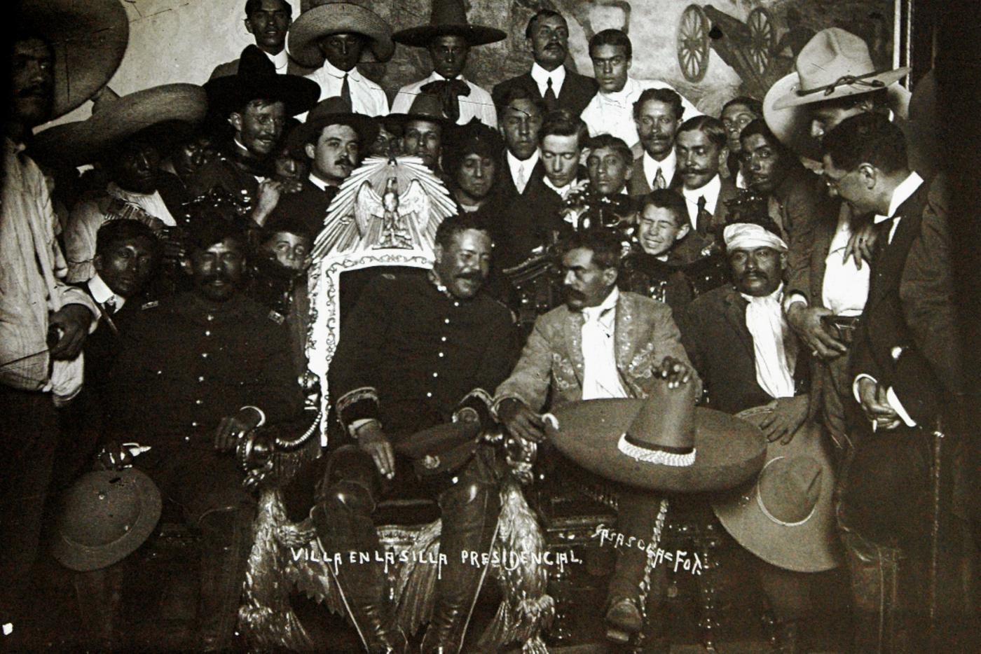 Лидер мексиканской революции Франсиско Вилья, он же "Панчо Вилья" в президентском кресле в окруженгии своих солдат в Национальном Дворце в Мехико 6 декабря 1914 года.