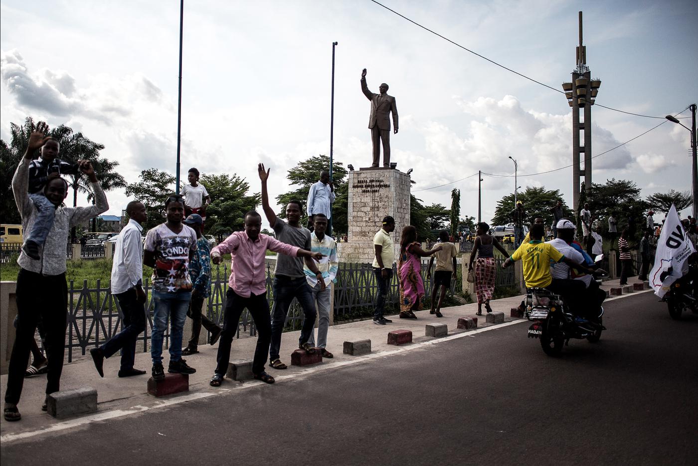 Жители Демократической Республики Конго поют возле памятника национальному герою Конго Патрису Лумумбе в Киншасе.