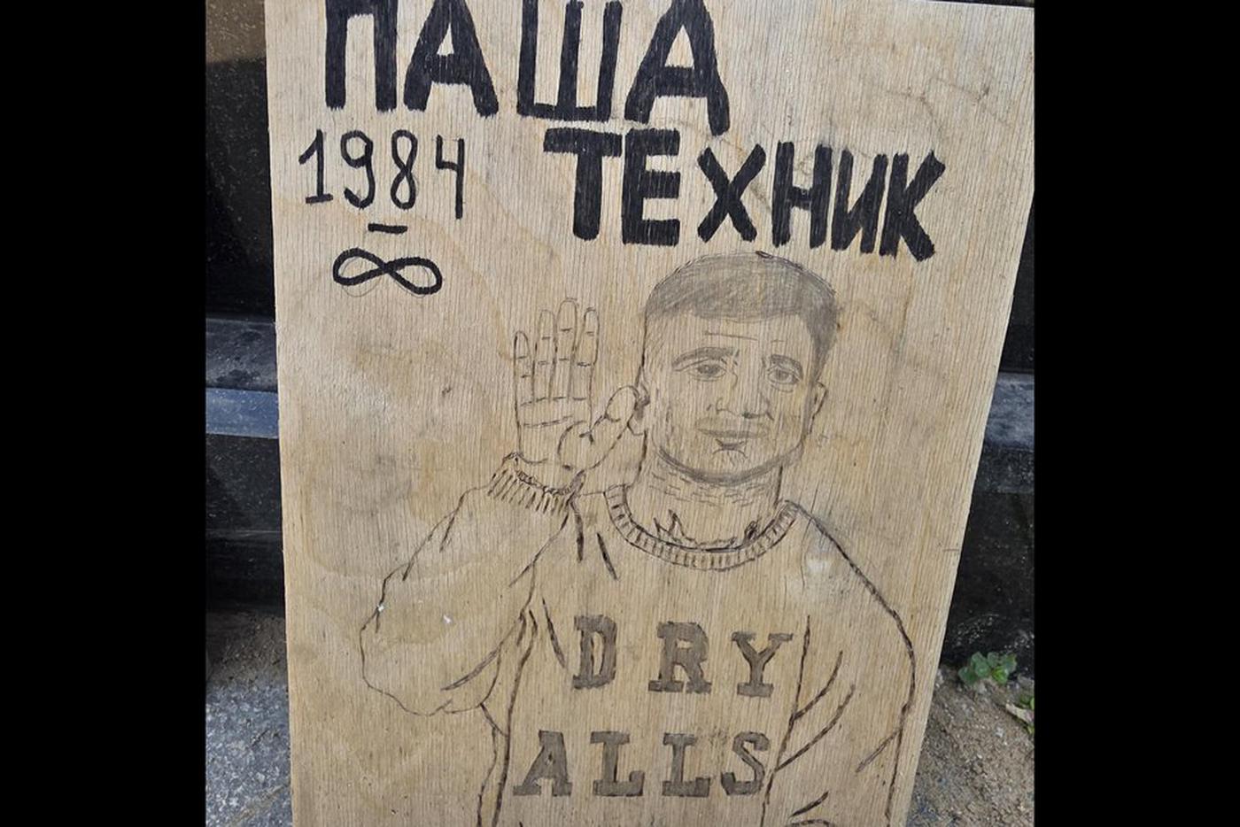 Люди несут рисунки на место упокоения Паши Техника.