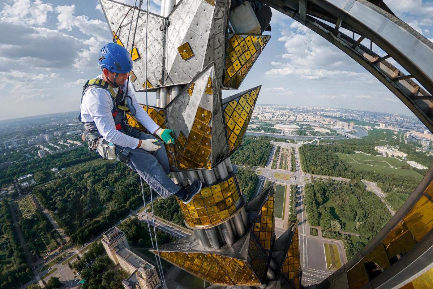 Промышленный альпинист демонтирует старое остекление
