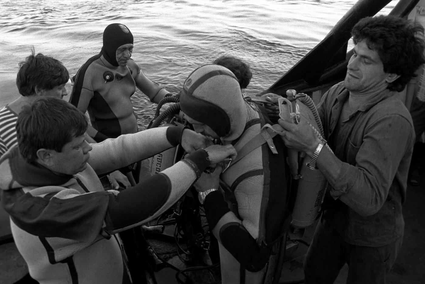 Водолазы спасательного судна "Аметист" Н. Моргалев (в центре) и Евгений Матюхин готовятся к погружению для поиска пропавших после гибели круизного лайнера "Адмирал Нахимов".